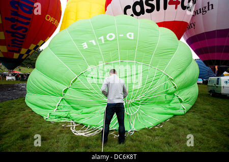 Bristol, Regno Unito. Il 10 agosto 2013. Un membro di equipaggio si prepara un palloncino prima della salita di massa al trentacinquesimo Bristol International Balloon Fiesta. Quasi mezzo milione di persone assisteranno i quattro giorni del festival che attira il palloncino equipaggi provenienti da tutto il mondo. 10 agosto 2013 Credit: Adam Gasson/Alamy Live News Foto Stock