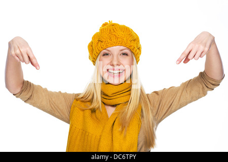 Sorridente giovane donna nel cappello e sciarpa con la punta rivolta verso il basso su uno spazio di copia Foto Stock