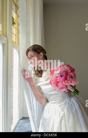 Sposa a guardare fuori dalla finestra Foto Stock