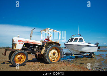 Trattore tirando una piccola barca al di fuori del mare Dymchurch Kent REGNO UNITO Foto Stock