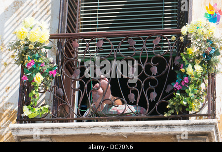 Tenendo semplice coppia di piedi visto in appoggio su un balcone a Salo, Italia, Europa Foto Stock