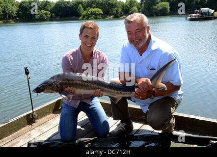 Esclusivo - Olandese Harry presentor Wijnvoord (R) e n-tv newscaster Christoph Hoffmann posano con un storione hanno catturato a 'Angelparadies Zwillbrock' (lit: paradiso della pesca Zwillbrock) in Vreden-Zwillbrock, Germania, 18 luglio 2013. Gli appassionati di pesca Harry Wijnvoord ha trascorso la giornata a insegnare ai giovani newscaster Christoph Hoffmann La secerne per la pesca sportiva. Lo Storione pesava dieci kg ma è stato rilasciato di nuovo dopo questa foto souvenir. Foto. HORST OSSINGER Foto Stock