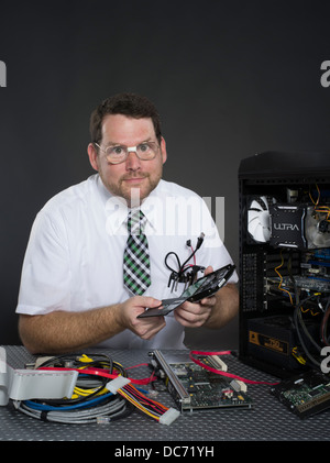 L'uomo con il computer e con vari componenti hardware Foto Stock