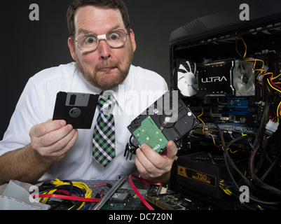 L'uomo con il computer e con vari componenti hardware Foto Stock