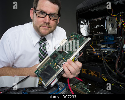 L'uomo con il computer e con vari componenti hardware Foto Stock