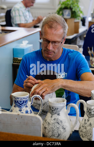 Delft, Paesi Bassi. 5 agosto 2013 - Potter pitture tradizionali colori bianco e blu Delft Pottery prima di essere cotta in un forno Foto Stock