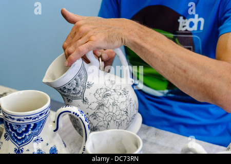 Delft, Paesi Bassi. 5 agosto 2013 - Potter pitture tradizionali colori bianco e blu Delft Pottery prima di essere cotta in un forno Foto Stock