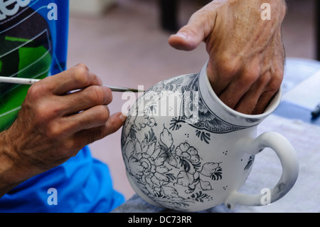 Delft, Paesi Bassi. 5 agosto 2013 - Potter pitture tradizionali colori bianco e blu Delft Pottery prima di essere cotta in un forno Foto Stock