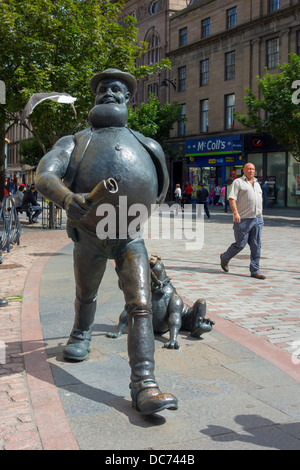 Statua del Dandy fumetto personaggio dei fumetti Desperate Dan nel centro città di Dundee dove il fumetto è stato pubblicato con uomo a camminare Foto Stock