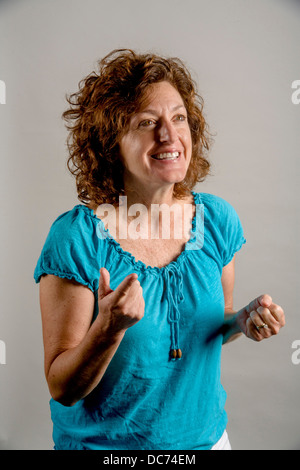 A 50 anni dai capelli auburn donna dimostra entusiasmo positivo. Foto Stock