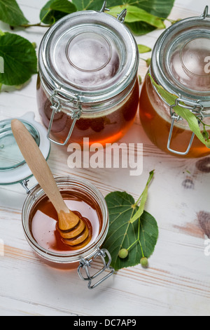 Il miele in un vaso e foglie di lime Foto Stock