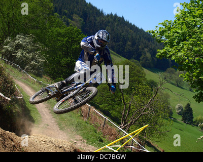 Mountain Biker salto sulla pista polverosa Foto Stock