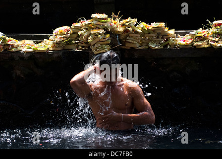 Un uomo prende un bagno al Tirta Empul Temple il 6 maggio 2013 a Bali, Indonesia. Foto Stock
