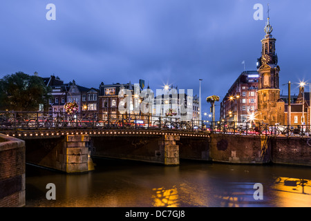 Un ponte sopra un canale di Amsterdam con la torre della Zecca landmark in background Foto Stock