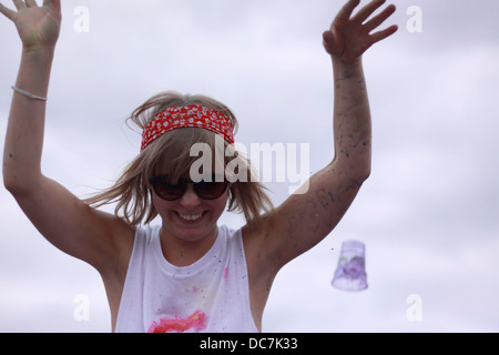 Ragazza coperto in blu holi colore colore in polvere divertimento eccitare gig festival ridere coperta faccia donna femmina Foto Stock