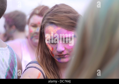 Ragazza coperto in blu holi colore colore in polvere divertimento eccitare gig festival ridere coperta faccia donna femmina Foto Stock