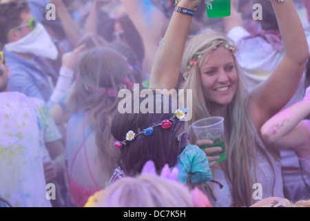 Ragazza coperto in blu holi colore colore in polvere divertimento eccitare gig festival ridere coperta faccia donna femmina Foto Stock