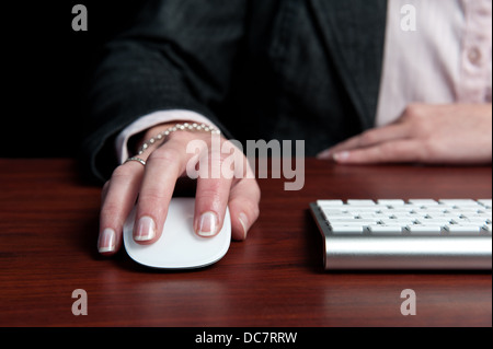 Giovane donna professionale tiene il mouse del computer con le belle mani e unghie. Foto Stock