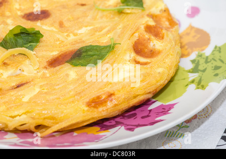 Close-up di una frittata con foglie di basilico e uno stile italiano frittata presentato su un piatto di portata Foto Stock