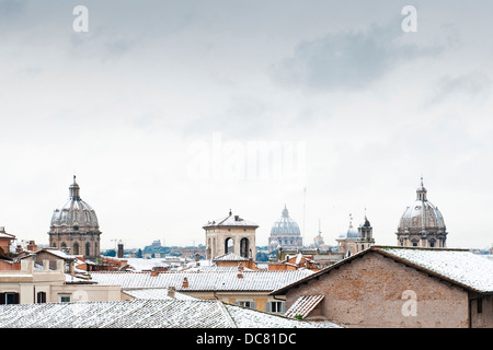Lo skyline di romano e la vista della Basilica di San Pietro, ricoperta di neve, Roma, Italia Foto Stock