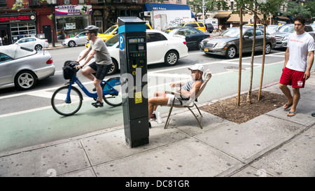 Conciate muscolare di uomo di mezza età in pantaloncini corti siede comodamente in poltrona patio sul marciapiede guardando il paraurti al traffico di paraurti di New York Foto Stock