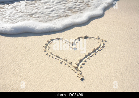 Amore cuore disegnato nella sabbia sulla spiaggia Foto Stock