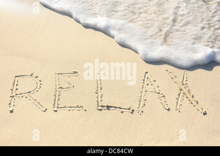 La parola "Relax" scritto nella sabbia sulla spiaggia Foto Stock