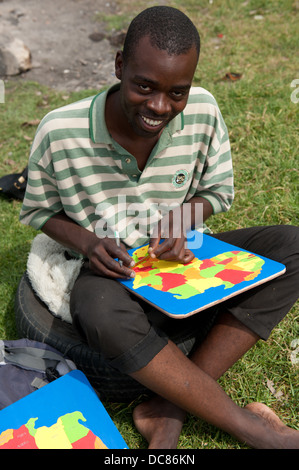 Artista facendo un puzzle al mercato dell'artigianato, Knysna, Western Cape, Sud Africa Foto Stock