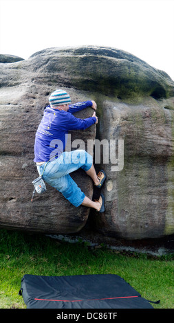 Rocciatore bouldering a bordo Burbage South, Derbyshire, Parco Nazionale di Peak District, Inghilterra, UK, Regno Unito, Foto Stock