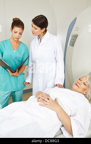 Medico e infermiere guardando i record medici del paziente senior in MRI Foto Stock