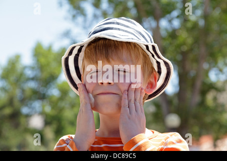 Ragazzo giovane sfregamento sunscreen sul suo volto, Isola di Rab, golfo di Kvarner, Croazia Foto Stock