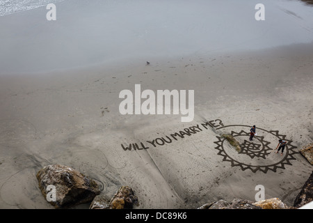 Vista aerea del matrimonio artistico proposta che viene scritto nella sabbia sulla spiaggia sotto la scogliera Foto Stock