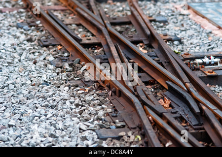 Vecchia ferrovia via arrugginito ghiaia di attraversamento della linea ferroviaria Foto Stock