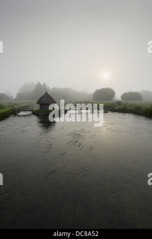 Fisherman's hut e anguilla trappole attraverso il Fiume Test sul Leckford Estate a Longstock. Hampshire. In Inghilterra. Regno Unito. Foto Stock