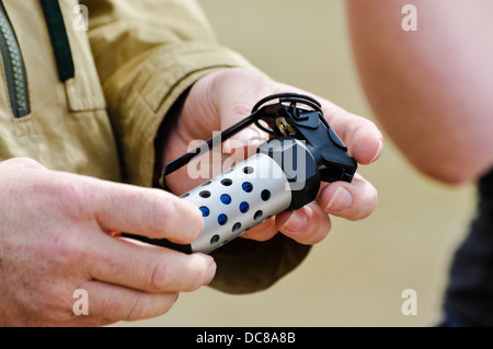 Un uomo detiene un fumo e blast, Granata, utilizzata dalla polizia e militari di disorientate e distrarre gli obiettivi. Foto Stock