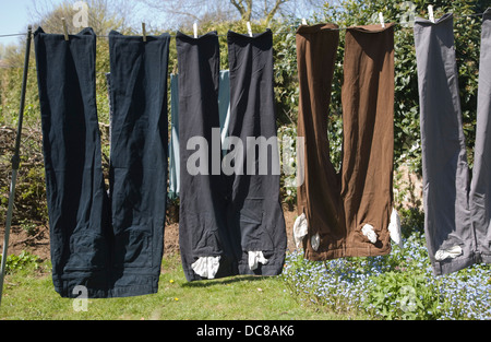 Linea di lavaggio pantaloni essiccamento in un giardino in una giornata di sole Foto Stock