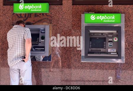 Un uomo preleva denaro da un macchina di ungherese banca OTP in Budapest, Ungheria, 05 agosto 2013. La OTP Bank è la più grande banca ungherese e attiva in Ungheria come pure in paesi stranieri. Foto: Jens KALAENE Foto Stock