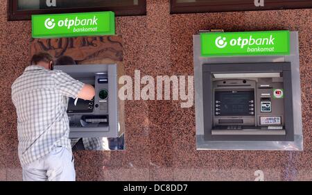 Un uomo preleva denaro da un macchina di ungherese banca OTP in Budapest, Ungheria, 05 agosto 2013. La OTP Bank è la più grande banca ungherese e attiva in Ungheria come pure in paesi stranieri. Foto: Jens KALAENE Foto Stock