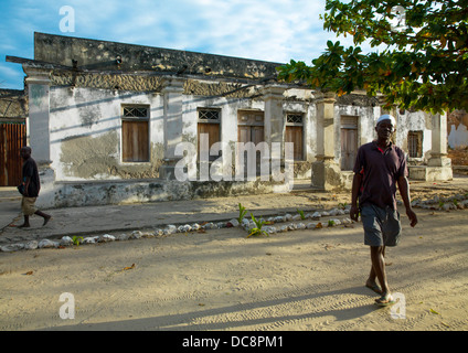 Gli uomini che passa di fronte a qualche Portoghese vecchio edificio coloniale, Ibo Island, Mozambico Foto Stock