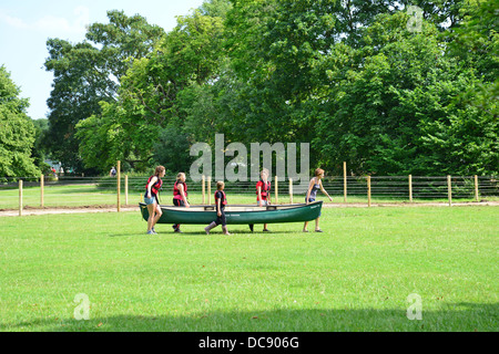 Bambini che portano i kayak torna al capannone in barca sul fiume Tamigi, Pangbourne, Berkshire, Inghilterra. Regno Unito Foto Stock