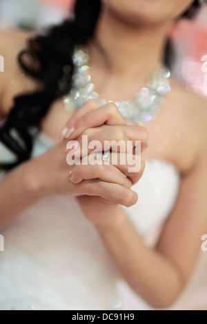 Anello di nozze su una sposa mani giunte, con anello di nozze su fuoco. Foto Stock