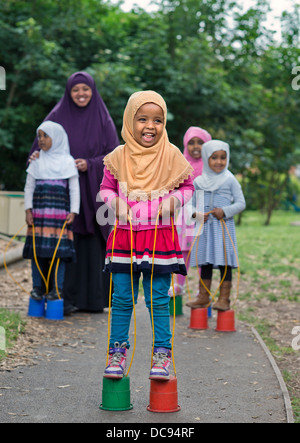 Il St. Pauls scuola materna e centro per l'infanzia, Bristol REGNO UNITO - ragazze somale giocando su palafitte nel parco giochi. Foto Stock