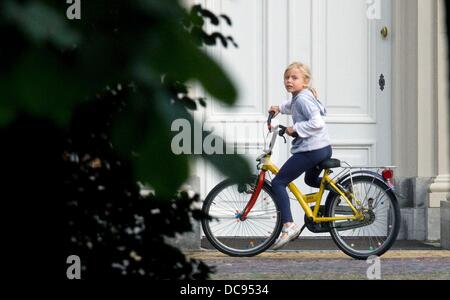 L'Aia, Paesi Bassi. 12 Ago, 2013. Figlia del principe Friso e principessa Mabel, Luna, vanno in bicicletta a Palazzo Huis ten Bosch dove il Principe Friso di Orange-Nassau morì a 44 anni all'Aia, Paesi Bassi, 12 agosto 2013. Il principe Friso era stato in un coma dal momento che un incidente di sci in Austria il 17 febbraio 2012. Foto: Albert Ph. van der Werf/EPR/dpa/Alamy Live News Foto Stock