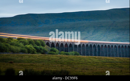 Fari di un treno, attraversando il viadotto Ribblehead, Ingleborough Riserva Naturale Nazionale, Yorkshire Dales. Foto Stock