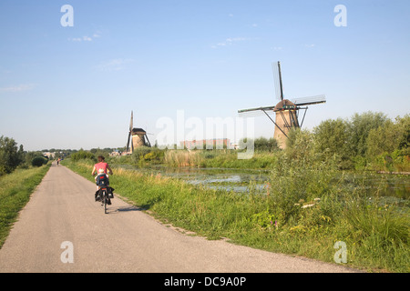Tradizionali mulini a vento olandese Kinderdijk Olanda ciclista sul percorso Foto Stock