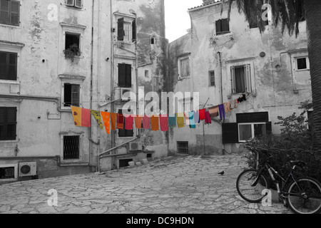 Lavaggio colorati appesi su una linea di lavaggio su una fotografia in bianco e nero dei vicoli in citta di Corfu in Grecia Foto Stock