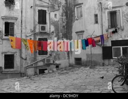 Lavaggio colorati appesi su una linea di lavaggio su una fotografia in bianco e nero dei vicoli in citta di Corfu in Grecia Foto Stock