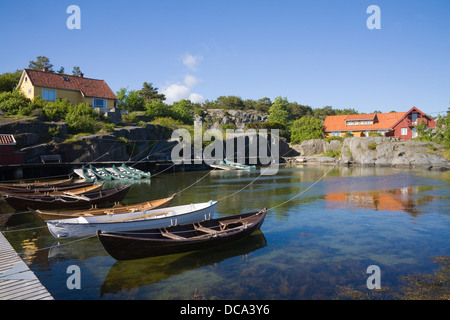 Høvåg Norvegia Europa imbarcazioni a remi e canoe ormeggiata in porto riparato con acqua proprietà anteriore Foto Stock