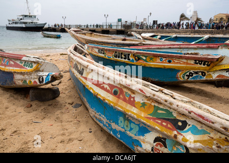 Barche di pescatori sulla spiaggia, Dakar-Goree ferry in background. Isola di Goree, Senegal. Foto Stock