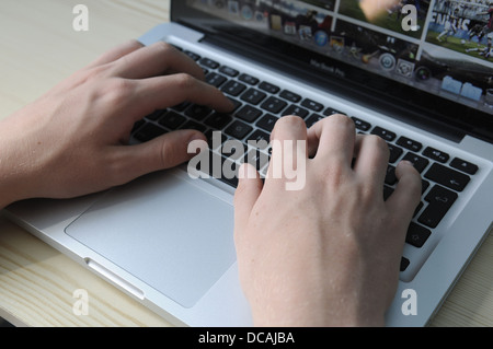 Chiusura del giovane uomo digitando su un MacBook Pro Apple computer portatile Foto Stock